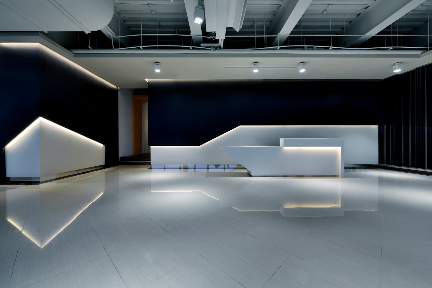 Modern reception desk with warm lighting against navy walls.